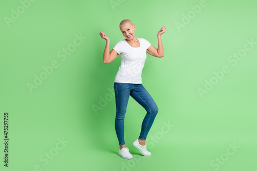 Full body photo of senior woman have fun dance wear casual clothes isolated over green color background