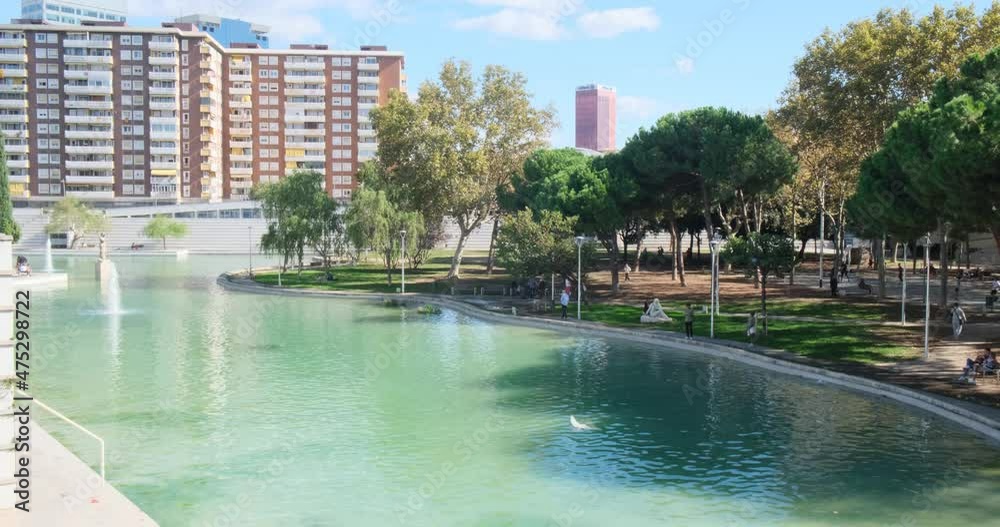Parc de l Espanya Industrial. Public park with lawns and trees, lake and sculptures