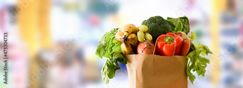 Photos Recyclable shopping bag full fruits and vegetables with supermarket background