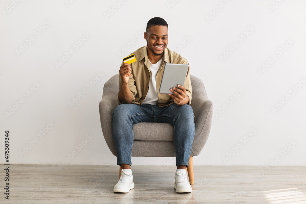 Man Using Tablet And Credit Card Shopping Online, Gray Background Man Using Tablet And Credit Card Shopping Online, Gray Background