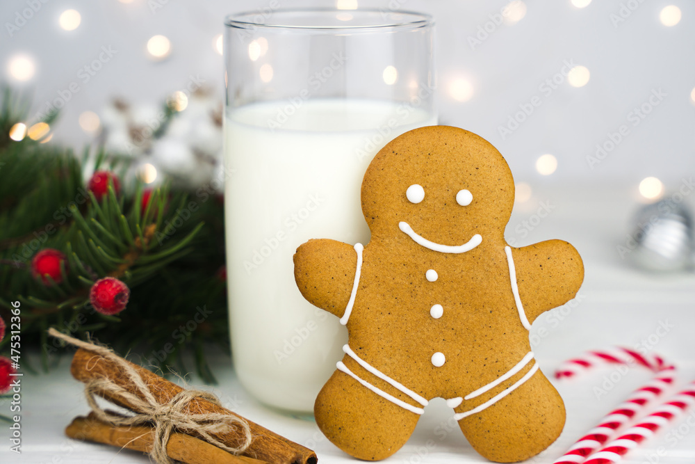 Gingerbread man and glass of milk on the table at the kitchen. A traditional Christmas treat for Santa Claus. Close-up. Gingerbread man and glass of milk on the table at the kitchen. A traditional Christmas treat for Santa Claus. Close-up.