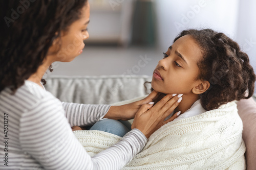 Foto Little girl suffering from sore throat, laying on couch