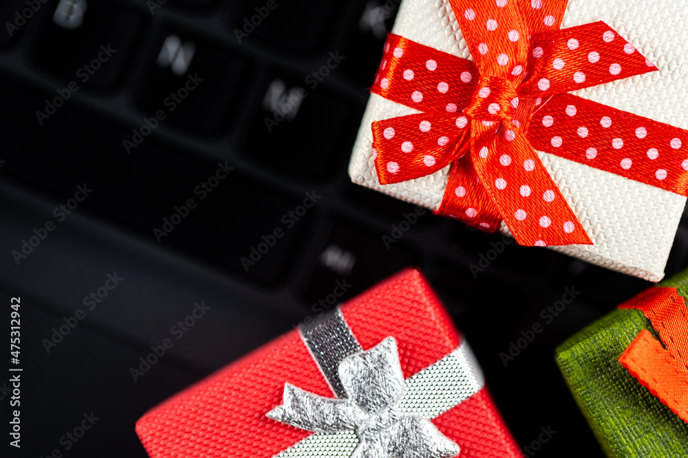 Small gift boxes arranged on the laptop keyboard. Cybersecurity of online shopping. Photo taken under artificial, soft light