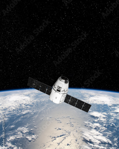 Fototapeta Naklejka Na Ścianę i Meble -  Cargo space craft and Earth planet. Dark background. Sci-fi wallpaper.Space Station Orbiting Earth.Space ship. Space art wallpaper.Solar Observatory.Elements of this image furnished by NASA.