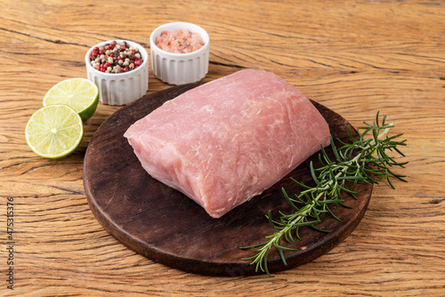 Quadro em tela Raw pork loin meat over wooden board with seasonings