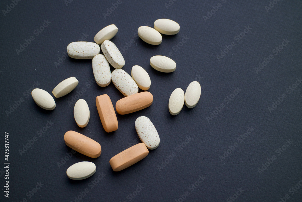 vitamins, tablets and pills lie on a black background. medicines are on the table. pills on a black background. vitamins, tablets and pills lie on a black background. medicines are on the table. pills on a black background.