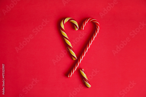 red heart shaped lollipop. Heart shaped with christmas candy canes on red horizontal background