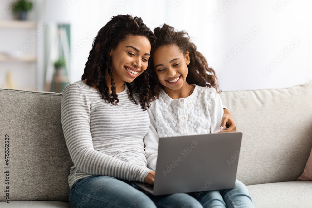 Happy african american mother and kid using laptop together Happy african american mother and kid using laptop together