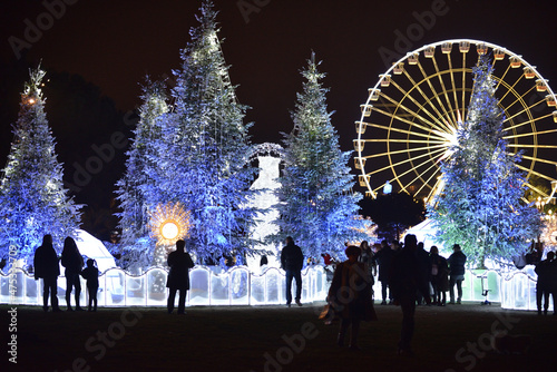 Christmas decorations with snow-covered trees and funfair Ferris wheel. Nice, France