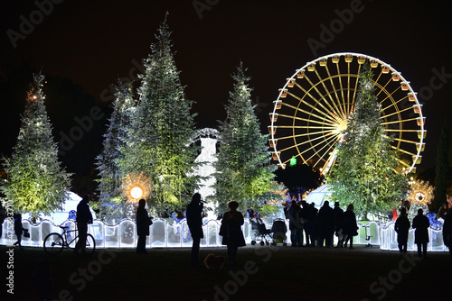Christmas decorations with snow-covered trees and funfair Ferris wheel. Nice, France