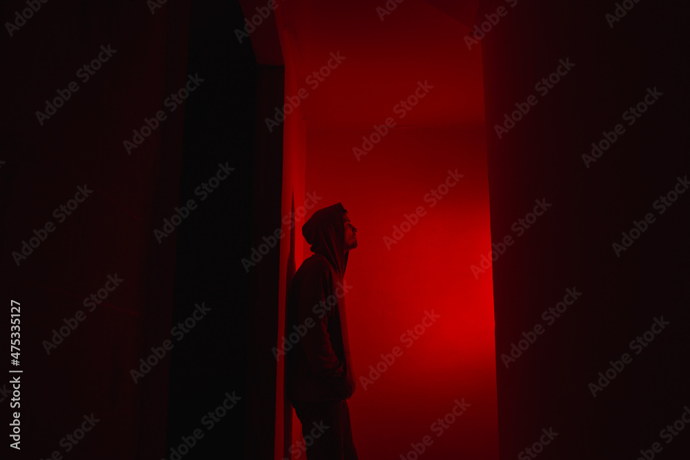 Silhouette of a man on a red background.
Silhouette of a guy in the dark.