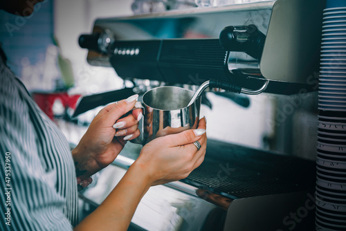 coffee machine is pourig coffee to white cup in bar