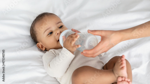 Obraz na plátně Little African American child drinking from baby bottle