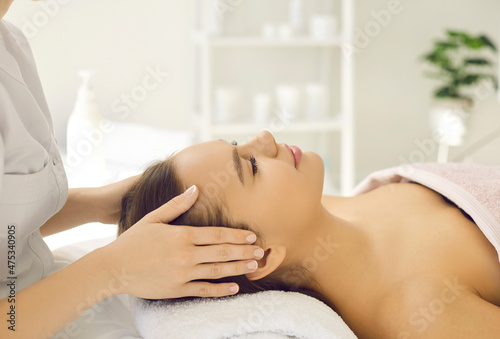 Beautician make facial skin care procedures for woman client in beauty saloon. Cosmetologist or dermatologist do lifting massage for female patient in aesthetic medicine clinic. Dermatology.