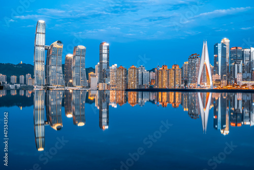 cityscape and skyline of downtown near water of chongqing at night photo
