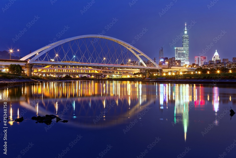 Night scenery of Taipei City with beautiful reflections of skyscrapers & bridges on the water by riverside at dusk ~ Cityscape of Taipei 101 Tower, Keelung River, Xinyi District & downtown in twilight