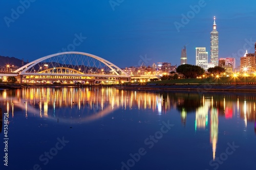 Night scenery of Taipei City with beautiful reflections of skyscrapers & bridges on the water by riverside at dusk ~ Cityscape of Taipei 101 Tower, Keelung River, Xinyi District & downtown in twilight