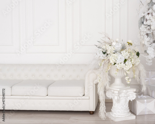 white sofa and white vase with flowers © Lyubov K