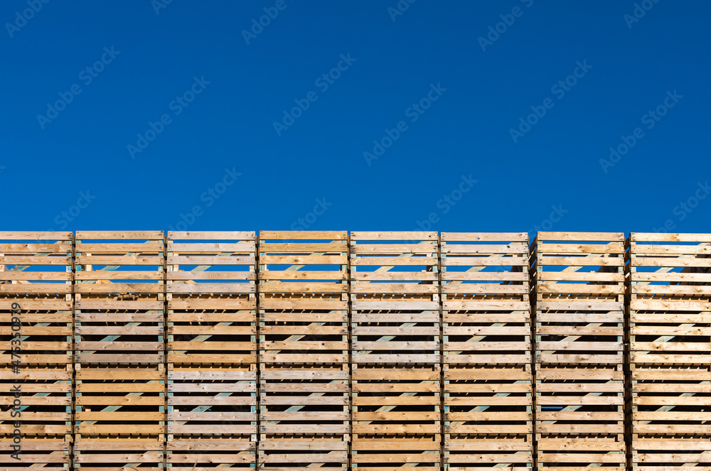 stack of empty pallets in front of blue sky