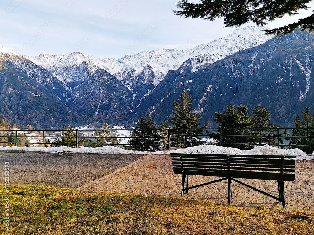 Panchina nel bosco con vista panoramica sulle cime delle Alpi innevate a Sondalo, in Valtellina. Italia Panchina nel bosco con vista panoramica sulle cime delle Alpi innevate a Sondalo, in Valtellina. Italia