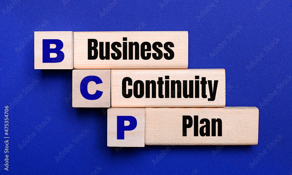 On a bright blue background, light wooden blocks and cubes with the text BCP Business Continuity Plan