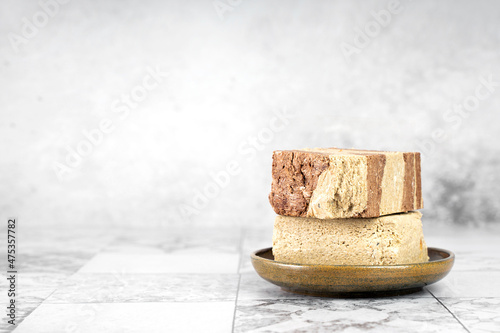 Tasty eastern sweet dessert halva from sunflower seeds, cocoa and tahini on gray background.Traditional dessert confection in Middle East, Balkans and west Asia.Horizontal.Copy space photo
