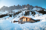 Winter mountain landscape in the Alps with traditional mountain huts
