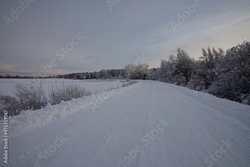 tire tracks in the snow, winter road, empty road in winter bends, covered with snow path, winter landscape