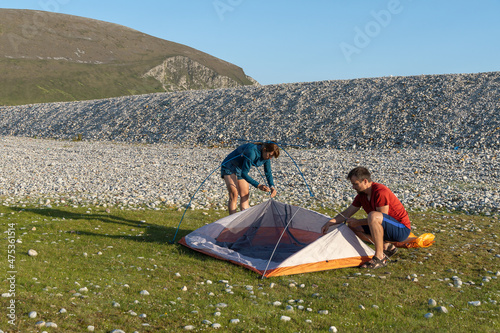 Camping people outdoor lifestyle couple putting up a tent