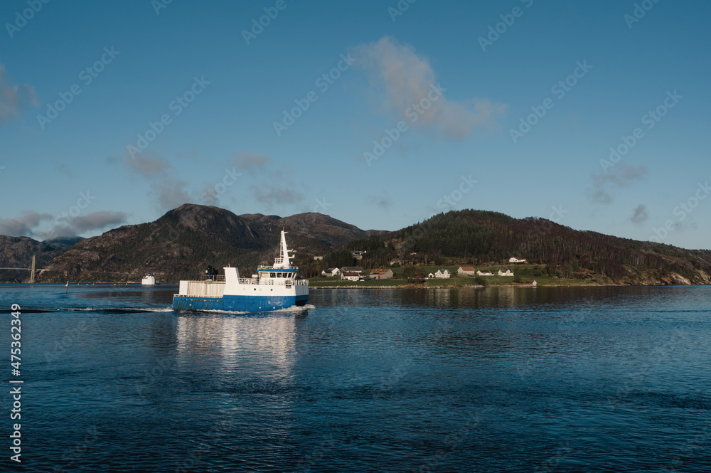 Beautiful landscape of Lusefjord. Mountains and small village. A floating ship.