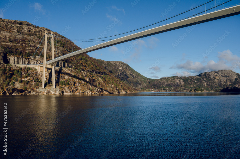 Scenic landscape of Lusefjord. Blue sky and water. Huge rocks. Bridge over the fjord. Beautiful nature of Norway.