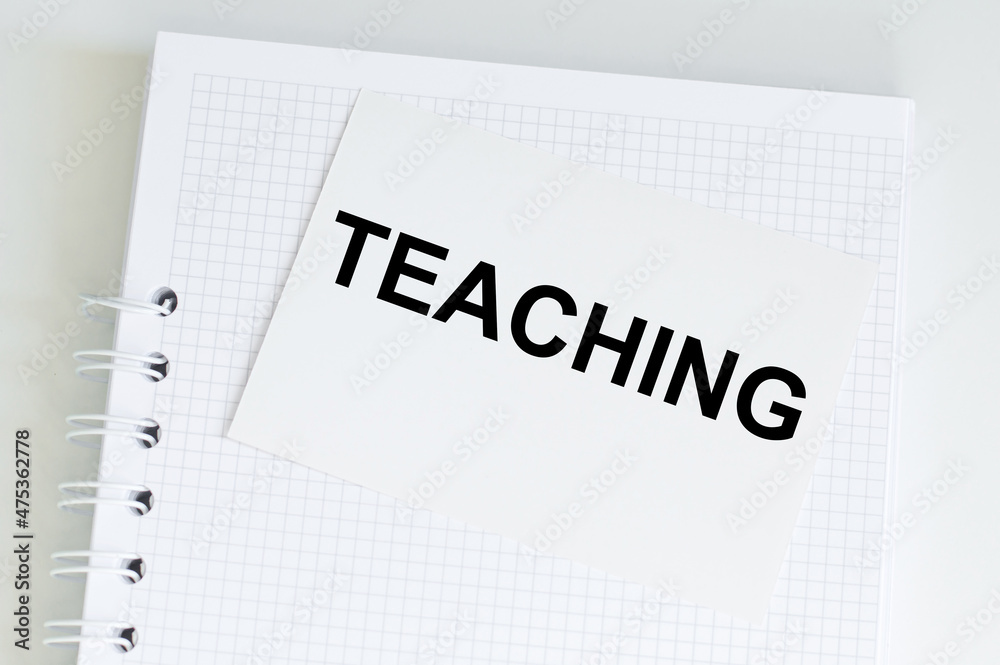 On the card text Teaching next to notepad on table, business concept On the card text Teaching next to notepad on table, business concept