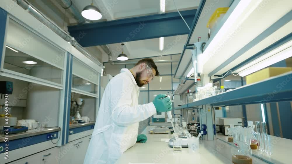 A scientist in a white coat works in a research laboratory. A scientist in a white coat works in a research laboratory.