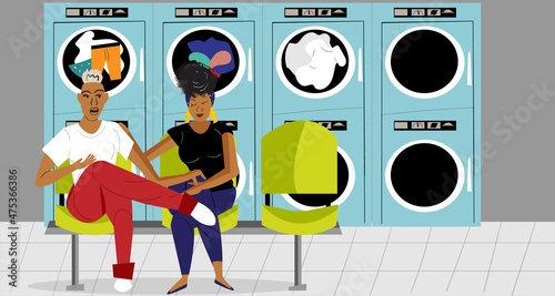 Lesbian couple in the laundromat talking while the clothes are drying 