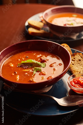 Bograch in pub. Vegetable soup with meat and hot chili peppers. Hungarian traditional food. Tomato soup with basil in a bowl.
