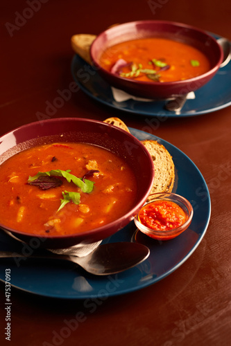 Bograch in pub. Vegetable soup with meat and hot chili peppers. Hungarian traditional food. Tomato soup with basil in a bowl.