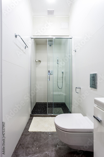 Contemporary small bathroom interior design. Glass shower cabin