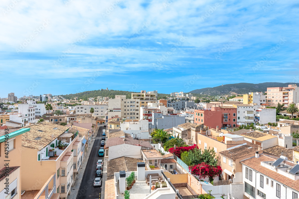 View from the heights of neighboring houses, with a road with cars and flowering plants between the houses, on the horizon you can see mountains View from the heights of neighboring houses, with a road with cars and flowering plants between the houses, on the horizon you can see mountains