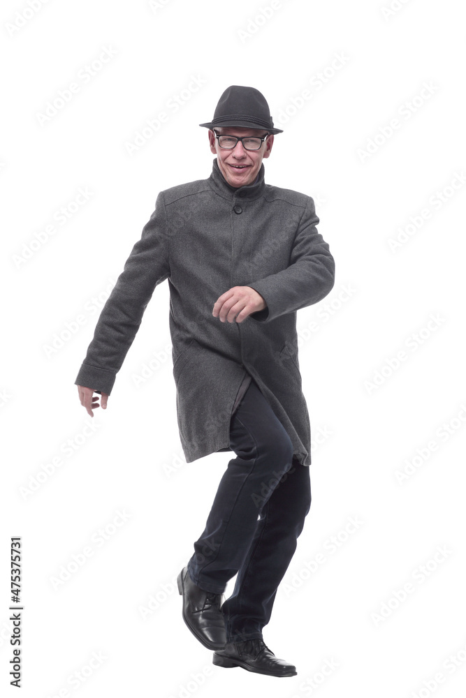 cheerful man in a hat and autumn coat striding forward .