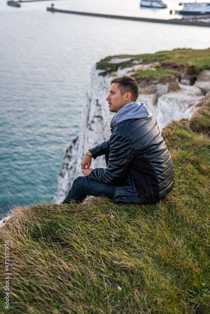 Young man exploring the White Cliffs of Dover in UK.