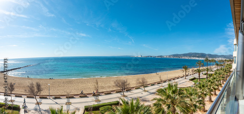 Views from a tall building of the bay of Palma de Mallorca, with the Can Pere Antoni beach in front and a promenade with palm trees. Blue Sky
