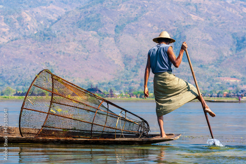 Inlay Lake, Shan State, Myanmar. Fisherman balances between his canoe and pole.
