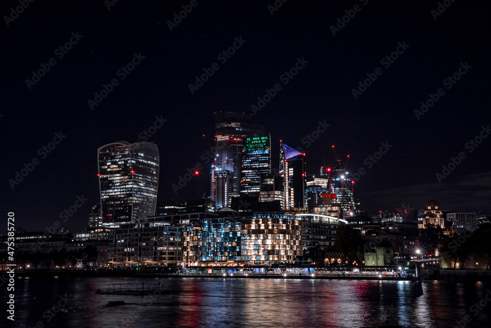Panoramic view of the London financial district with many skyscrapers in the center of London at night. Panoramic view of the London financial district with many skyscrapers in the center of London at night.