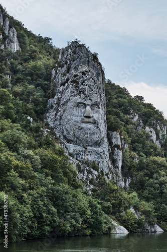 Vertical shot of the Rock Sculpture of Decebalus under a cloudy sky in Romani photo