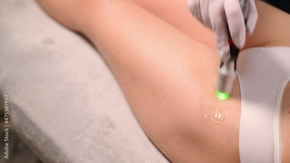 Professional cosmetologist doing laser hair removal of bikini area to young woman in beauty salon. Close up. Professional cosmetologist doing laser hair removal of bikini area to young woman in beauty salon. Close up.
