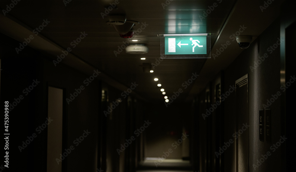 Exit sign inside a hotel hallway. This indicators show to tourists the direction they have to go in case of an iminent danger.