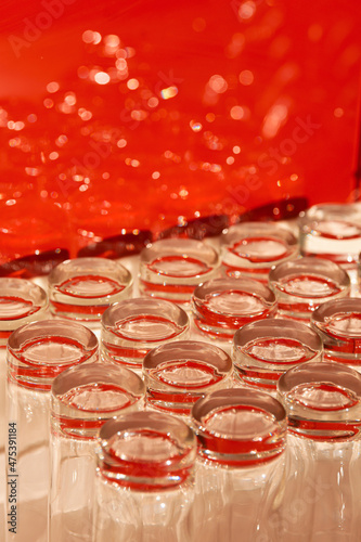 A lot of empty clean glasses used for water and juice are placed on a table and are ready to be served.