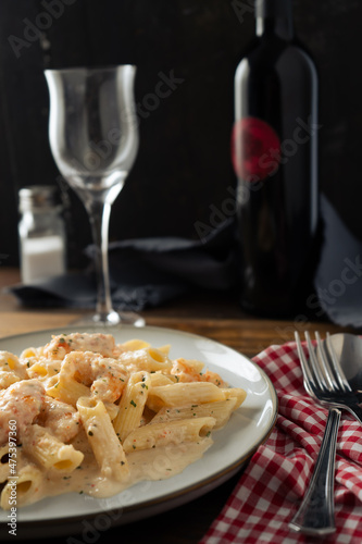 An exquisite plate of penne rigate pasta with a delicious shrimp and prawn cream served on a still life table