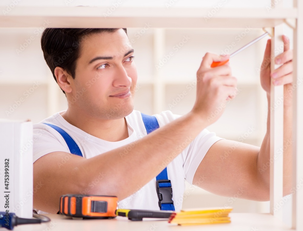 Worker man repairing assembling bookshelf Worker man repairing assembling bookshelf