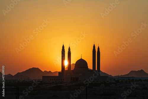 Middle East, Arabian Peninsula, Oman, Ad Dakhiliyah, Nizwa. The sun setting behind the Sultan Qaboos Grand Mosque.